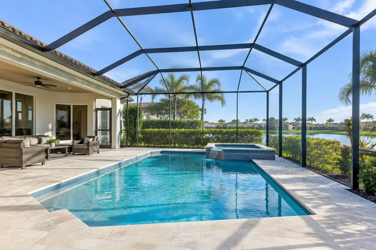 Enclosure frame over a pool with a raised spa and patio seating